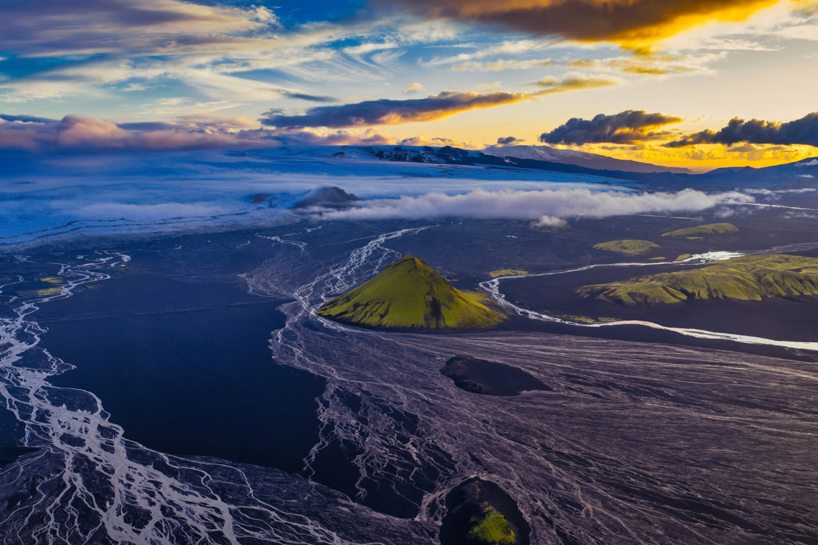 Maelifell, Iceland — green volcanic peak amid braided glacial rivers at sunset